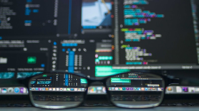 Code on dark screens viewed through glasses representing the developer tooling ecosystem